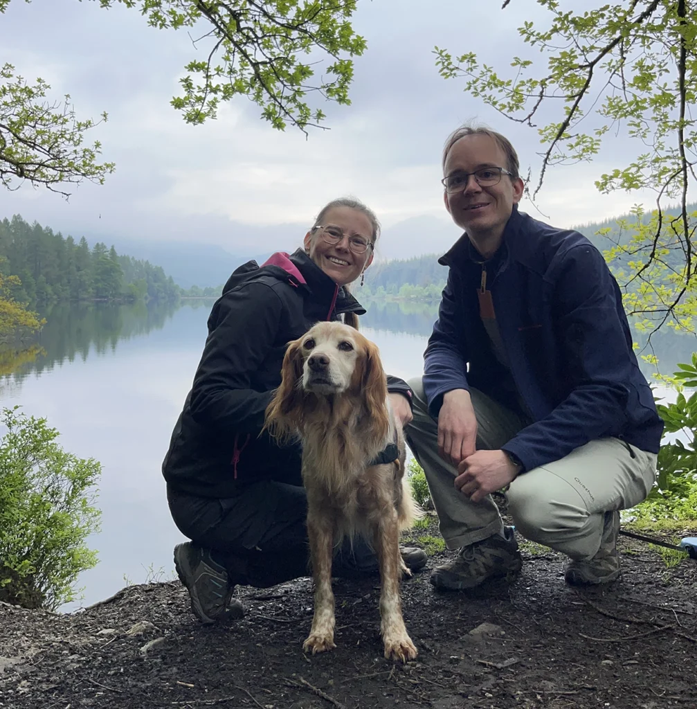 couple avec un chien qui pose devant un lac