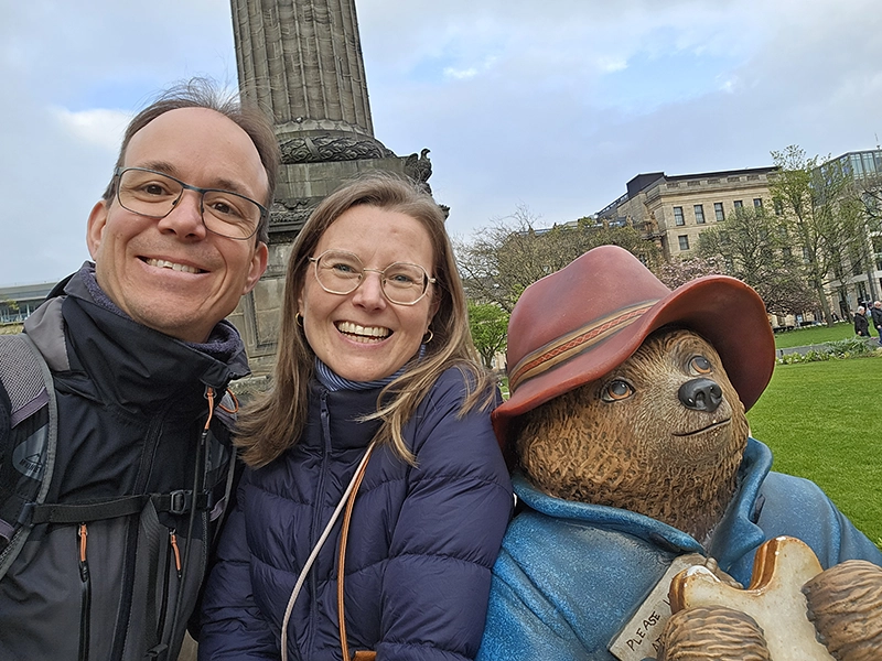 Couple qui se prend en photo à Edimbourg à coté de la photo de Paddington